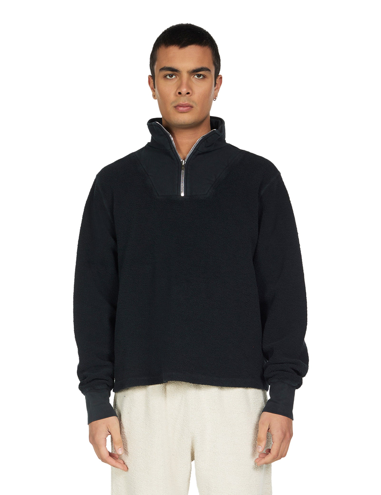 Man wearing a black quarter-zip sweatshirt on a white background