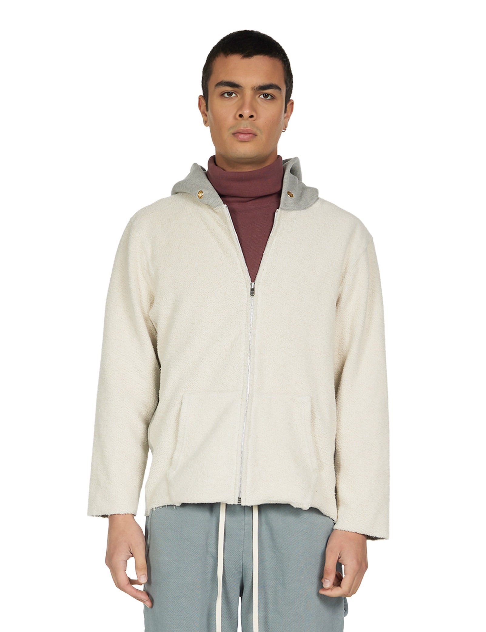 Man wearing an inside out heather grey zip hoodie over a maroon turtleneck on a white background