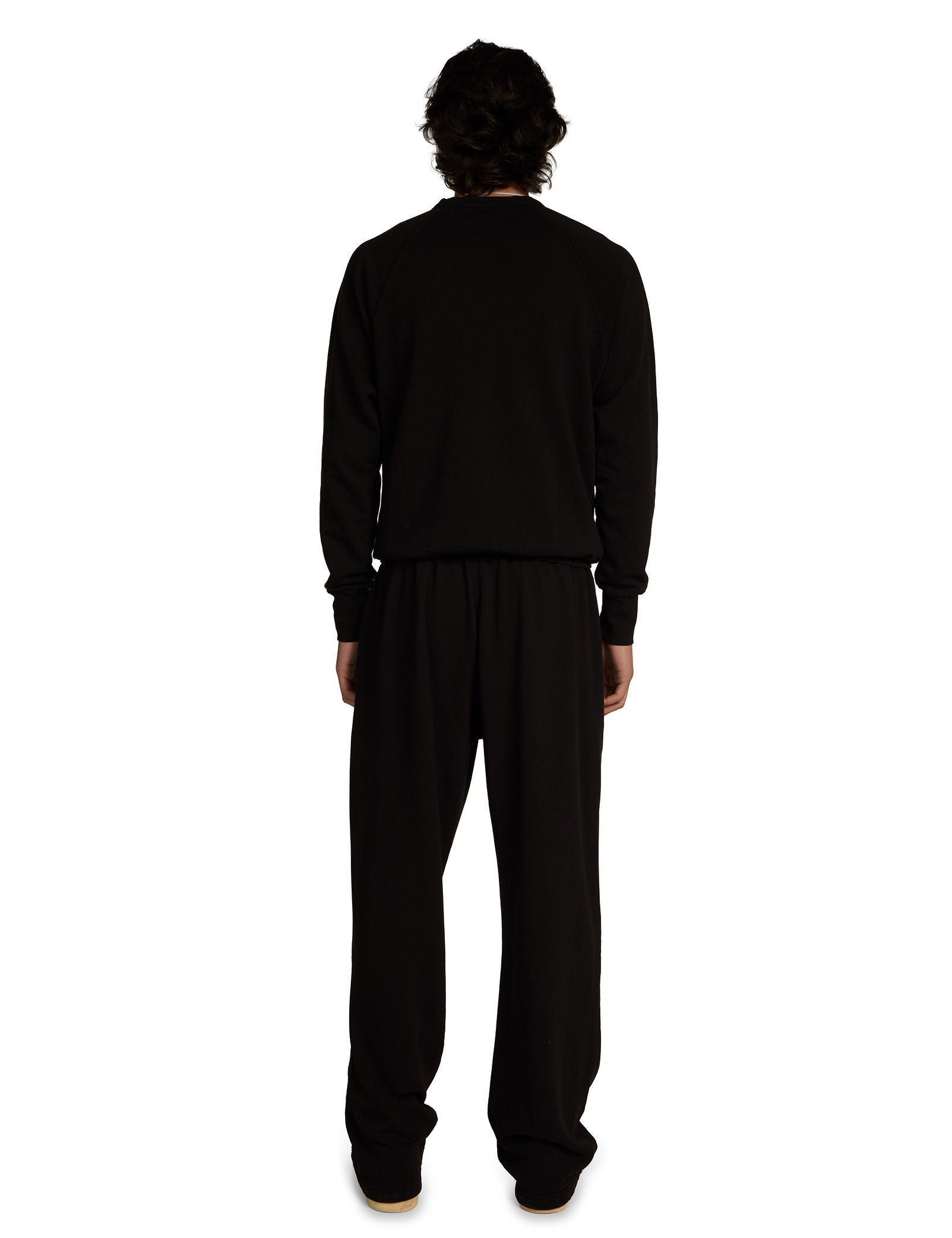 Person wearing a black outfit on a white background